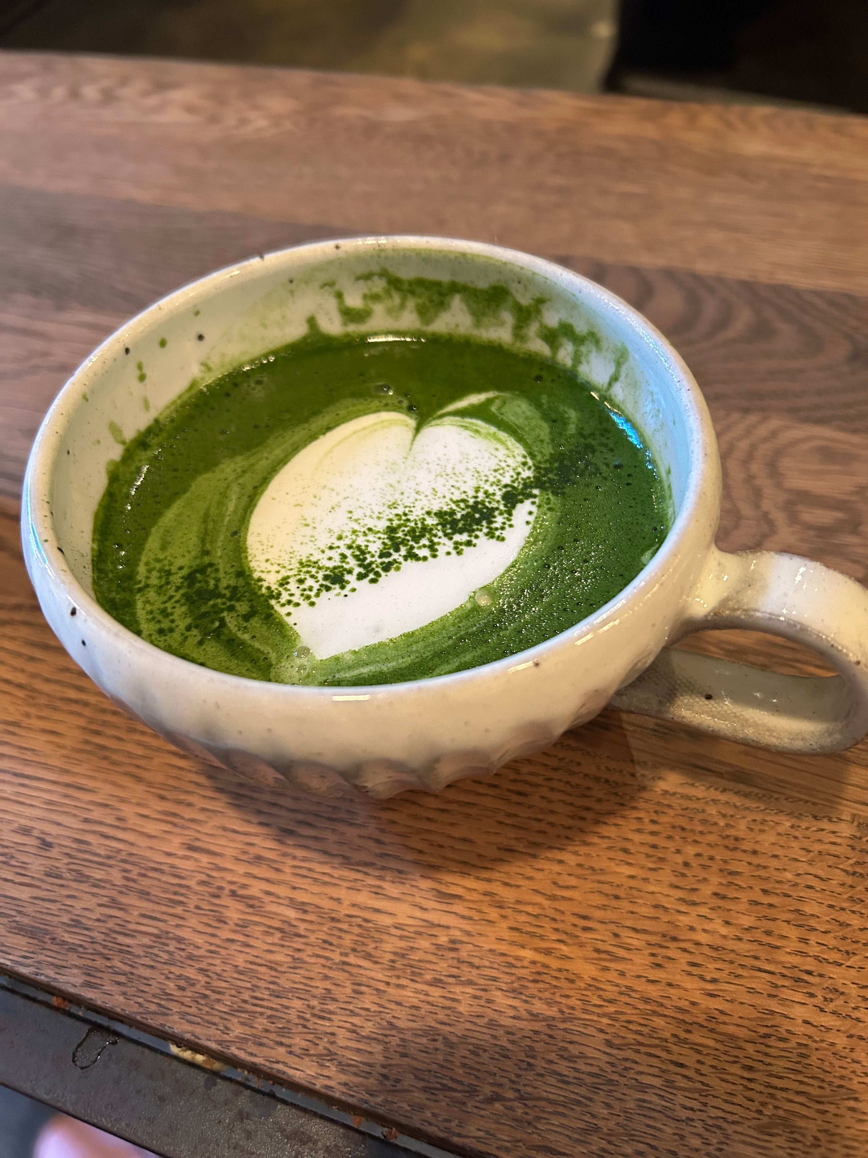 A cup of matcha tea on a dark wooden table